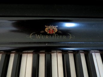 A  Wurlitzer Piano With Bench, Metronome And Assorted Sheet Music