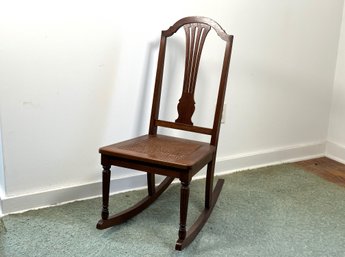 A Beautiful Antique Rocking Chair With A Caned Seat