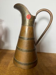 AN ANTIQUE HAND HAMMERED ARTS AND CRAFTS PITCHER