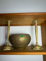 TWO MIDDLE EASTERN BRASS CANDLESTICKS AND A BRASS BOWL