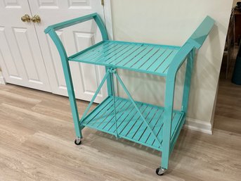 A Turquoise Tiered Metal Cart On Casters