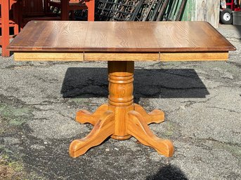 An Extendable Oak Pedestal Base Dining Table