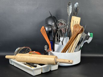 A Large Assortment Of Kitchen Utensils In A Sectioned Holder