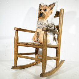 A Child's Rocking Chair And Canine Themed Accent Pillow