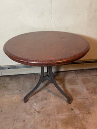 A SOLID BURLED WALNUT TABLE WITH IRON BASE