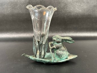 A Whimsical Cast-Metal Bunny, Rowing On A Leaf Boat With A Glass Trumpet Vase