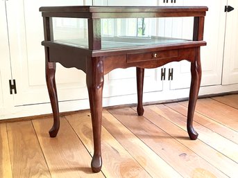 A Vintage Display Table With Glass Top