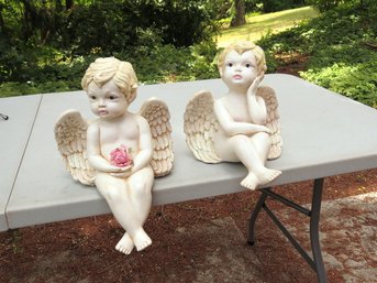 A Pair Of Table Edge Seated Ceramic Cherubs