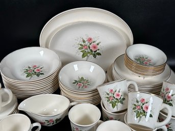 An Assortment Of Vintage Dinnerware With A Rose Bloom Motif