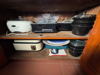 CABINET FULL OF ROASTERS, CROCKPOTS, AND WARMING TRAYS