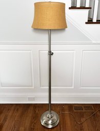 A Brushed Steel Standing Lamp With Hessian Cloth Shade