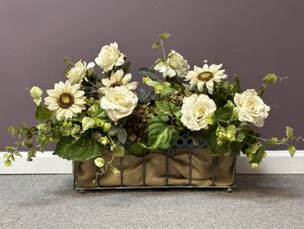 An Elegant Faux Floral Arrangement In A Burlap-Lined Wire Basket