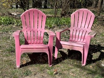 A Pair Of Adirondack Chairs In Pink Plastic