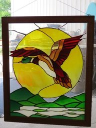 Stained Glass Window Of A Duck Flying Across The Face Of The Sun