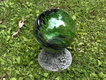 A Handblown Gazing Ball On A Cast-Cement Stand