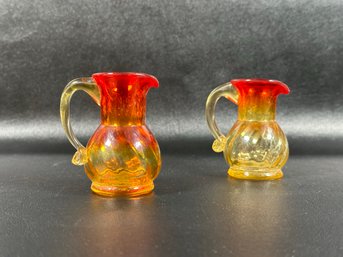 A Pair Of Small Vintage Pitchers In Amberina Glass