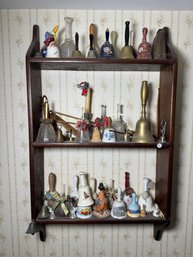 AN ANTIQUE SHELF WITH A BELL COLLECTION