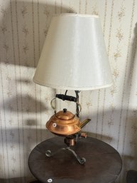 A WROUGHT IRON AND COPPER KETTLE LAMP