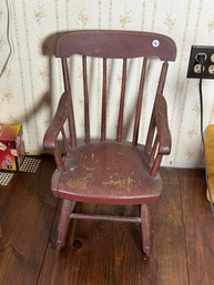 AN ANTIQUE CHILDS ROCKER IN RED PAINT
