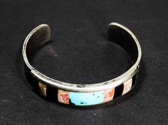 SOUTHWESTERN STERLING SILVER CUFF BRACELET HAVING INLAID TURQUOISE, CORAL AND ONYX