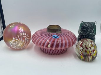 THREE VINTAGE GLASS PAPERWEIGHTS AND A PEPPERMINT SWIRL OIL LAMP