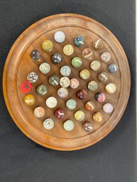 AN ANTIQUE MARBLE BOARD WITH LABELED STONE MARBLES
