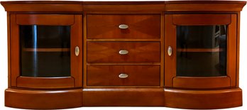 An Elegant Media Console With Curved Paneled Glass Doors