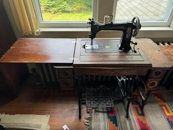 A WHEELER AND WILSON OAK TREADLE SEWING MACHINE