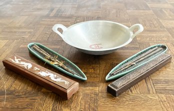 An Assortment Of Chopsticks, And A Tin Cooking Bowl