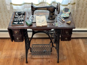 An Antique Singer Treadle Sewing Machine With Accessories & Instruction Booklet