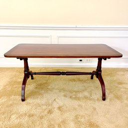 A Mahogany Coffee Table With A Banded Edge And A Turned Trestle Base