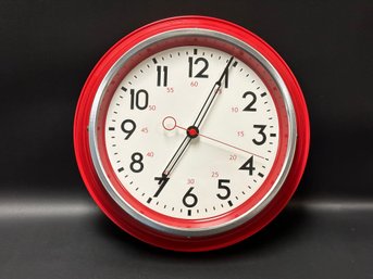 A Wall Clock With A Red Case & White Face