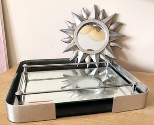 A Mirrored Vanity Tray And Sun Form Mirror