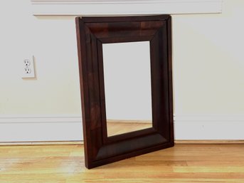 An Antique Mirror In A Veneered Frame