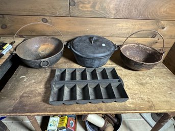 THREE CAST IRON POTS AND A CORN BREAD PAN