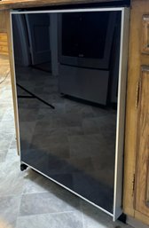 A Sub Zero Cabinet Freezer With Black Glass Door Panel