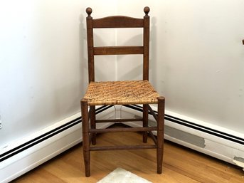 A Small Vintage Chair With A Chevron-Pattered Woven Seat