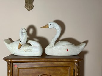 A PAIR OF CARVED AND PAINTED WOODEN SWANS