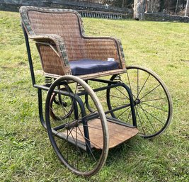 A Magnificent Antique Wheel Chair With Wicker Seat