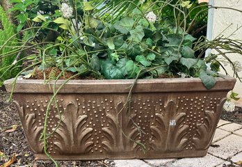 A Terra Cotta Planter With Faux Greener