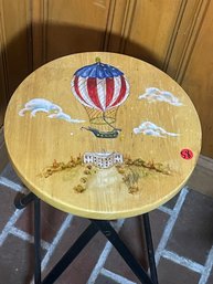 A HAND PAINTED STOOL WITH A RED WHITE AND BLUE BALLOON OVER THE WHITE HOUSE