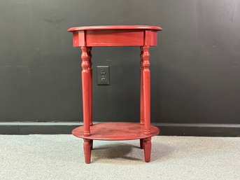 A Small Two-Tiered Side Table In Red