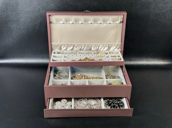 A Traditional Tiered Jewelry Box Filled With Sparkly Costume Jewelry