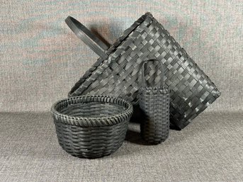 A Grouping Of Woven Baskets In Black