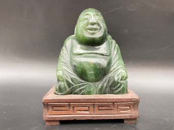 Carved Stone Buddha On A Wooden Stand.