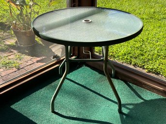 A Small, Glass-Topped Outdoor Dining Table