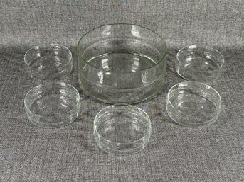 A Modern Glass Serving Bowl With Compatible Salad Bowls