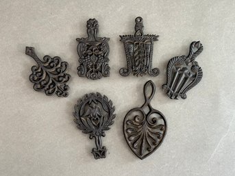 A Collection Of Small, Decorative Vintage Trivets In Cast Iron