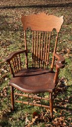 AN OAK PRESS BACK ARM CHAIR