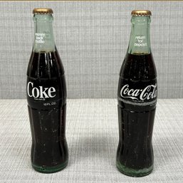 A Pair Of Vintage Coke Bottles